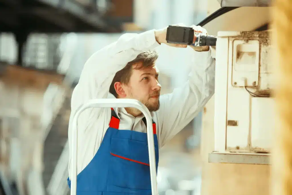 technicien rge en train d'installer une climatisation murale d'une pac air air